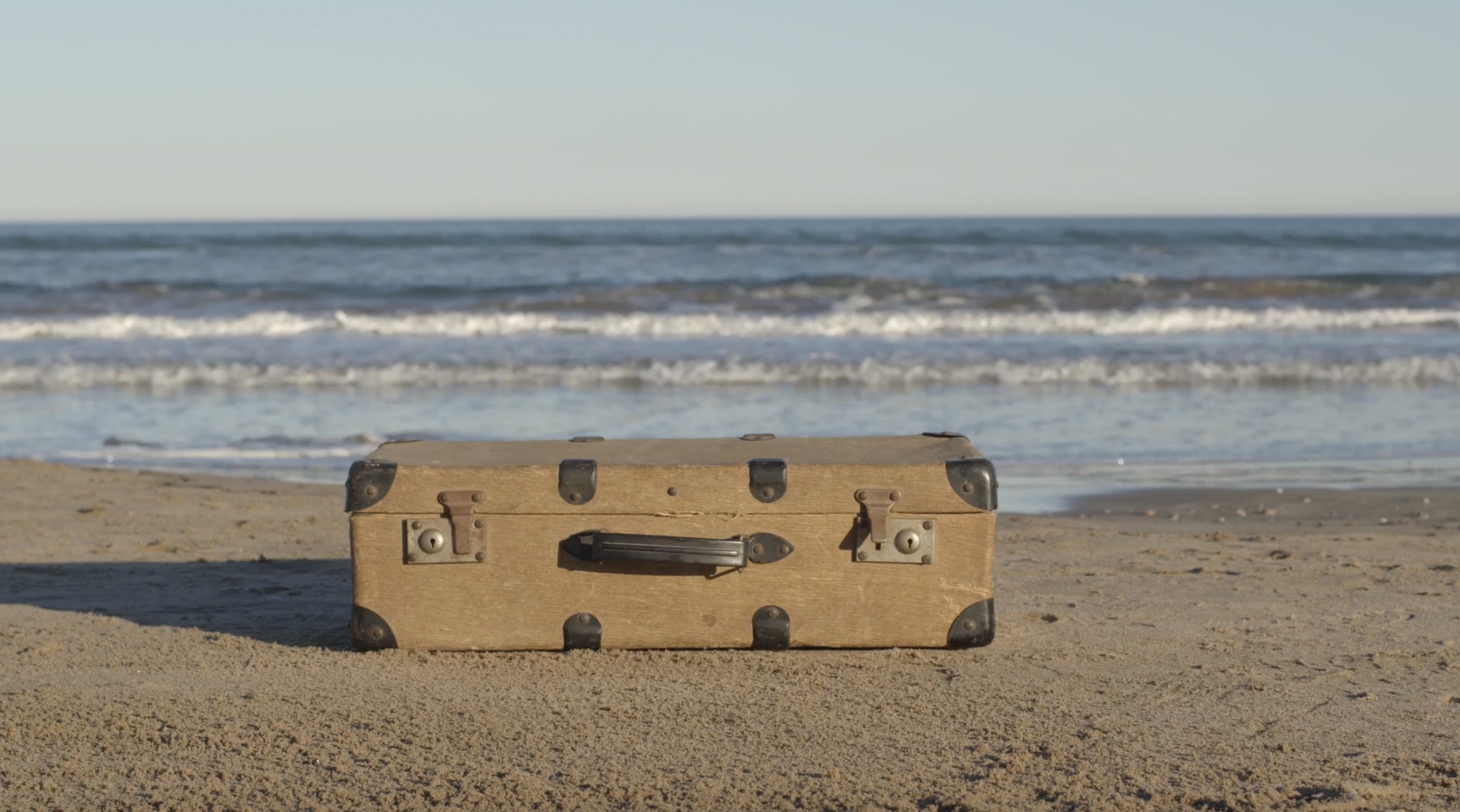 maleta en la playa en el documental Exilis